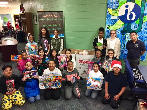 Sawyer Road students holding toys gathered from a Toys for Tots toy drive